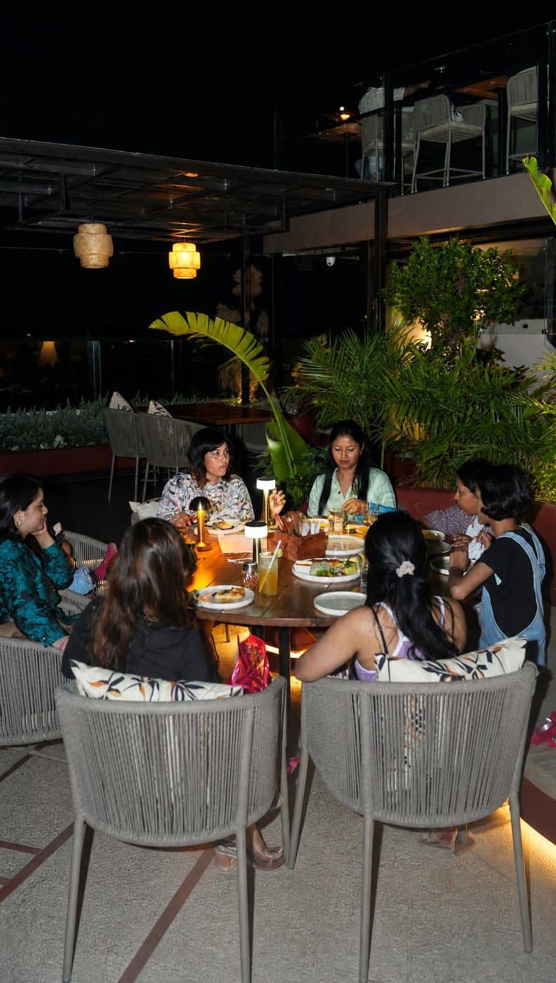 A group of friends dining together on the rooftop at night